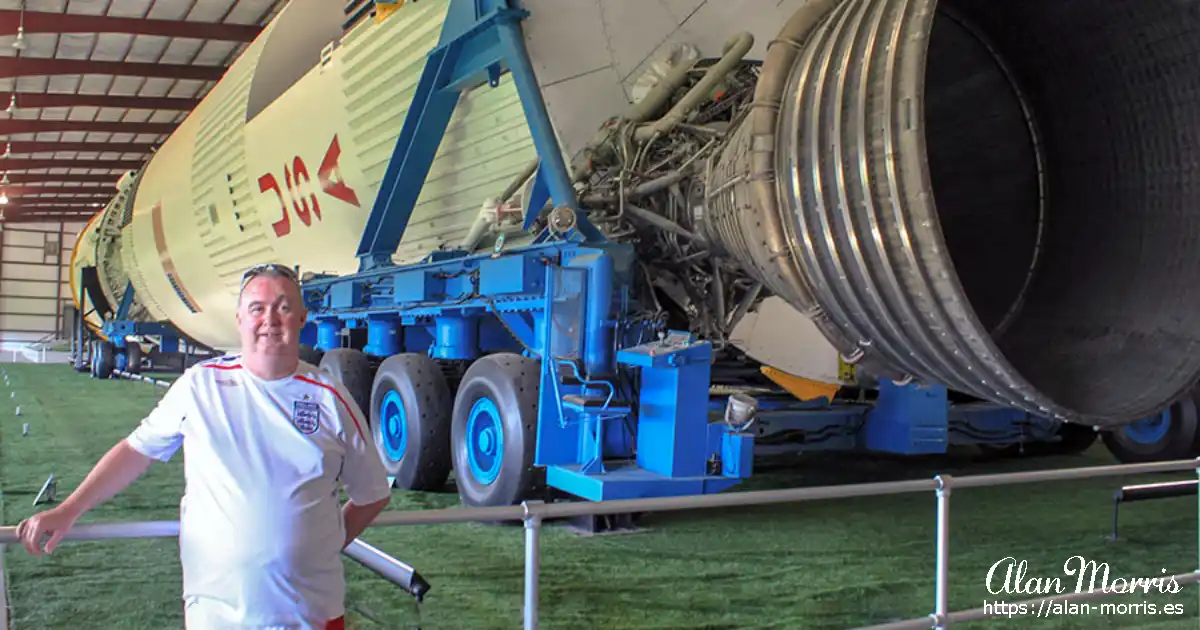 Alan Morris next to an Apollo rocket at Houston.